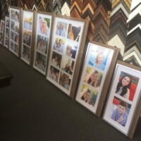 framed family photos lined up on floor